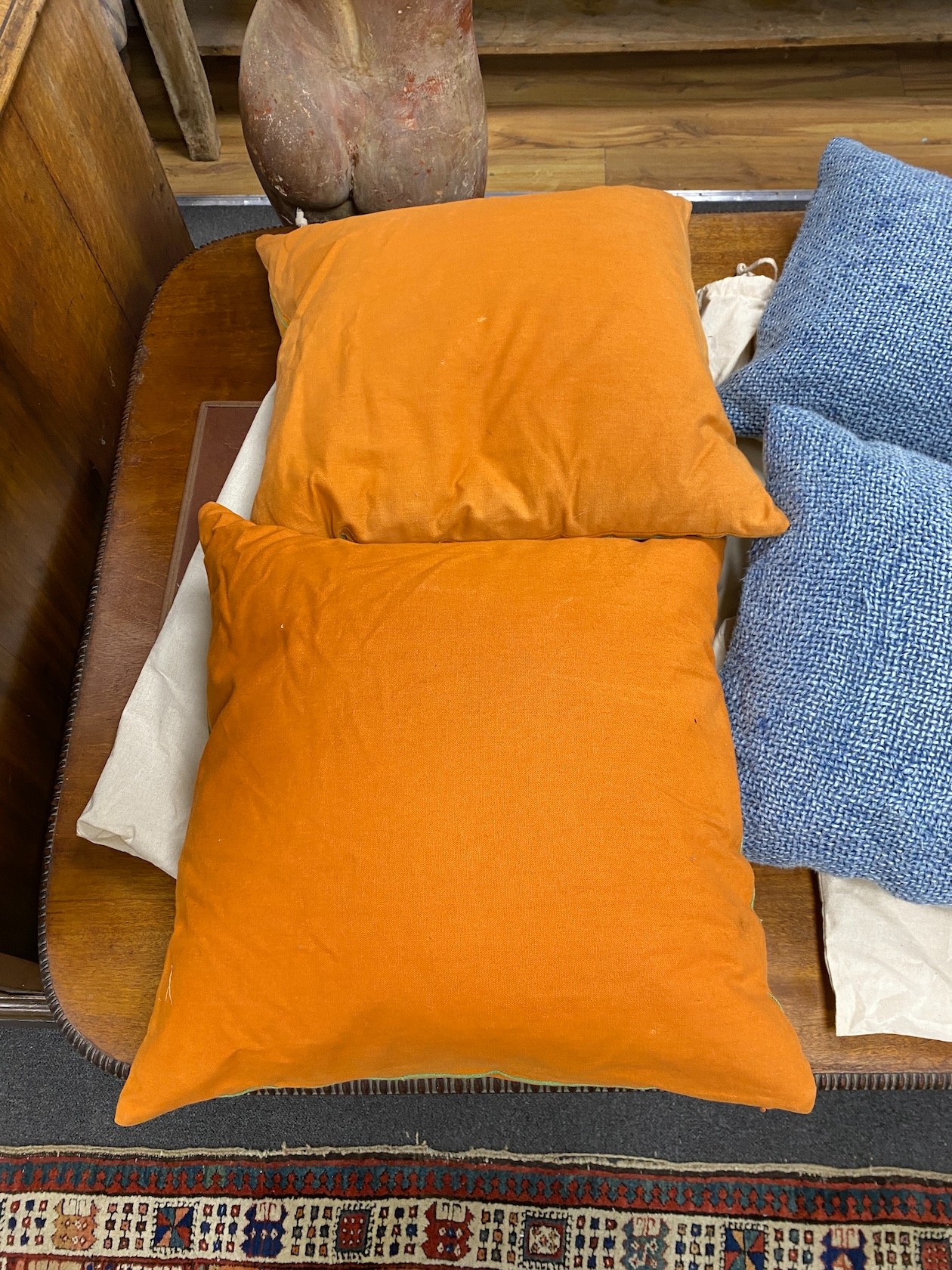 Two pairs of polychrome floral embroidered and blue woven cushions, larger 50cm square.